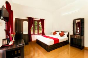 una camera con letto e TV a schermo piatto di Three Roots Resort a Sultan Bathery