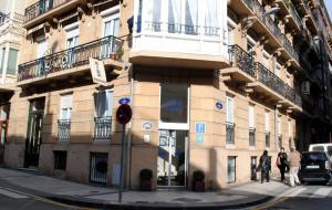 um edifício na esquina de uma rua com pessoas a passar por ele em Pension Aida em San Sebastián