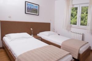 two beds in a room with two windows at Villa Lumare - 100m from the sea in Pula