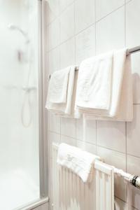 a bathroom with white towels hanging on a wall at Hotel Daub in Bremervörde