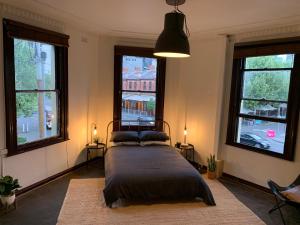um quarto com uma cama num quarto com janelas em Central Club Hotel em Melbourne
