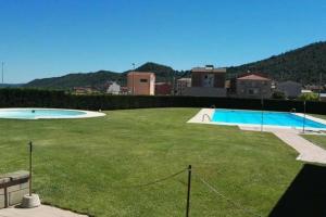 a large grassy yard with a swimming pool at Apartamento 1 Cal Genís - WIFI in Montmajor