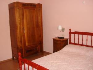 um quarto com uma cama e um armário de madeira em La Casetta dei Cuori em Averara
