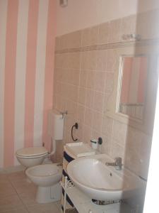 uma casa de banho com um WC branco e um lavatório. em La Casetta dei Cuori em Averara