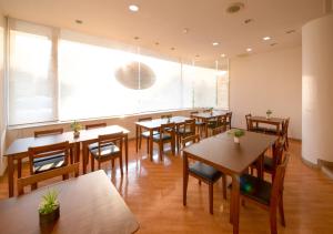 小松市小松机场酒店的餐厅设有桌椅和大窗户。