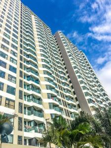 een hoog gebouw met palmbomen ervoor bij Angela House Ha Long in Ha Long