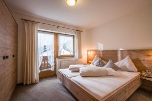 a bedroom with a large bed with a large window at Apart Heim in Fügen