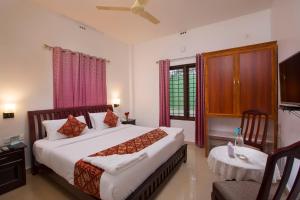 1 dormitorio con 1 cama grande y 1 mesa en Misty Lake Resorts, Munnar, en Munnar
