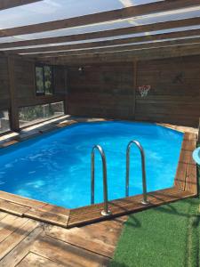 a large swimming pool with a wooden deck and two metal bars at MARILLUNA aixoplucrural in Montblanquet
