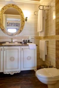 a bathroom with a sink and a toilet and a mirror at L'Agora Old Town Hotel & Bazaar in Izmir