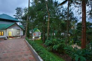 una casa con una pasarela frente a un jardín en Misty Lake Resorts, Munnar, en Munnar