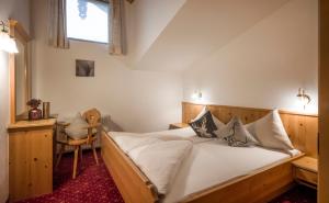 a bedroom with a bed and a desk and a window at Apart Heim in Fügen