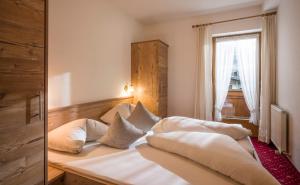 a bedroom with a bed with pillows and a window at Apart Heim in Fügen