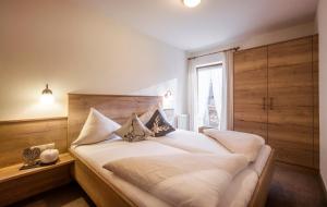 a bedroom with a large bed with white sheets and pillows at Apart Heim in Fügen
