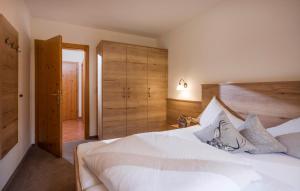 a bedroom with a white bed and wooden cabinets at Apart Heim in Fügen