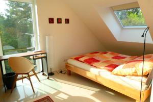 a bedroom with a bed and a desk and a window at Otterhaus in Trippstadt