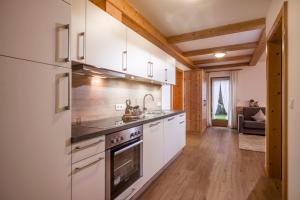 a kitchen with white cabinets and a stove top oven at Apart Heim in Fügen