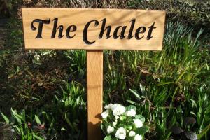 セント・アグネスにあるThe Chalet at Mellowveanの花の前のチョーカーを読む看板