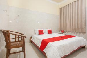 ein Schlafzimmer mit einem großen Bett mit roten Kissen in der Unterkunft RedDoorz Syariah At Sedati in Surabaya