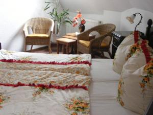 a room with a bed with pillows and chairs at Zum Achten Himmel in Klotten