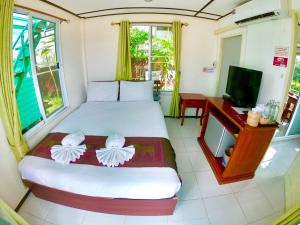 ein Schlafzimmer mit einem Bett, einem Schreibtisch und einem Fernseher in der Unterkunft Revolution Hostel Pai in Pai