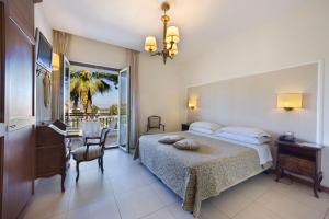 a bedroom with a bed and a table and a desk at Hotel Alpha in Sant'Agnello