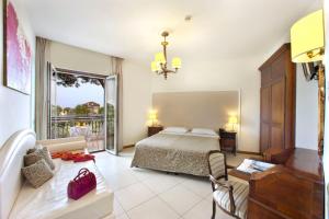 a bedroom with a bed and a desk and a couch at Hotel Alpha in Sant'Agnello