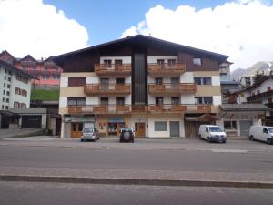 a large building with cars parked in front of it at Appartamento Cristallo di Ghiaccio in Passo del Tonale