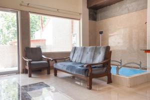 a waiting room with a chair and a tub at RedDoorz Syariah At Sedati in Surabaya