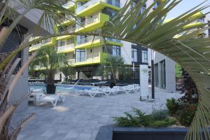 a building with a courtyard with tables and chairs at On Beach-Mamaia Residence in Mamaia Sat/Năvodari