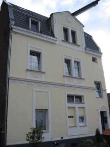 un edificio blanco con ventanas y un reloj en él en Köln Vermietung Schwermer, en Colonia