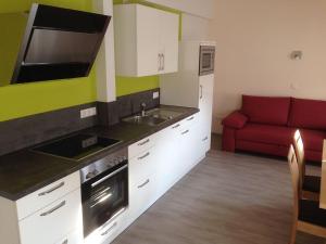 a kitchen with a red couch in a room at Kasarme Auszeit in Nördlingen