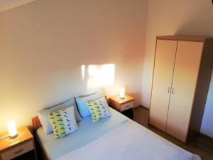 ein Schlafzimmer mit einem Bett mit zwei Lampen und einem Schrank in der Unterkunft Apartment Anzotika in Nin