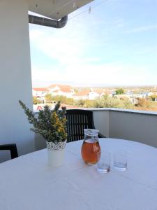 einen Tisch mit einer Vase Blumen und zwei Gläsern in der Unterkunft Apartment Anzotika in Nin