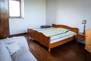 una camera con letto, divano e finestra di Agriturismo Dacapo ad Agliano Terme