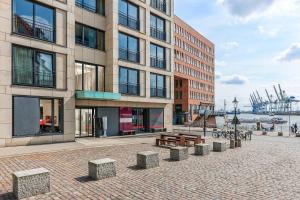 a building with benches in front of a harbor at Clipper Boardinghouse - Hamburg-Holzhafen in Hamburg