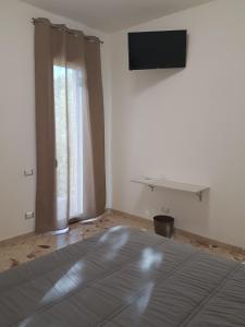 a bedroom with a bed and a television on a wall at Al Bosco Ficuzza in Ficuzza