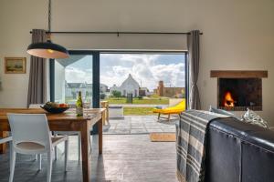 a living room with a dining table and a fireplace at Amia House Struisbaai in Struisbaai