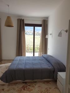 a bedroom with a bed and a large window at Al Bosco Ficuzza in Ficuzza