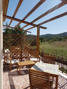 a patio with wooden tables and chairs with a view at Al Bosco Ficuzza in Ficuzza