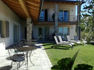 eine Terrasse mit Tischen und Stühlen und ein Haus in der Unterkunft Relais Colle San Giorgio in Bardolino