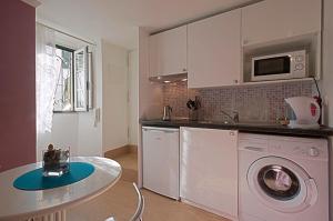 a kitchen with a washing machine and a table in it at Alfama in Lisbon