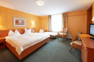 um quarto de hotel com duas camas e uma televisão em Göbel's Gästehaus Hotel am Park em Willingen