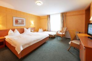ein Hotelzimmer mit 2 Betten und einem TV in der Unterkunft Göbel's Gästehaus Hotel am Park in Willingen