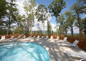 une terrasse avec une piscine, des chaises et des arbres dans l'établissement Simply Breathtaking #36, à Sevierville