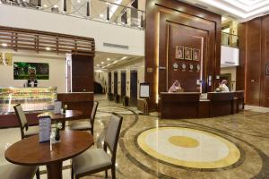 a restaurant with tables and chairs and a counter at Zaha Al Munawara Hotel in Al Madinah