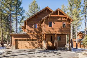 a log home with a garage in the snow at Gray Bear 454 in Mammoth Lakes