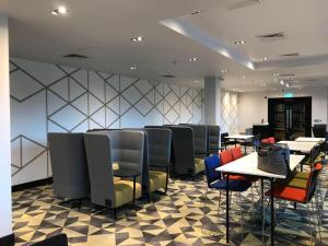 a dining room with tables and chairs in a restaurant at Village Hotel Coventry in Coventry