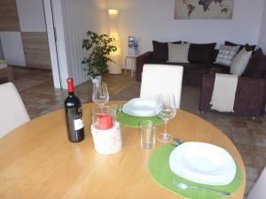 a wooden table with a bottle of wine and glasses at Ferienwohnung Weyl in Eschbach