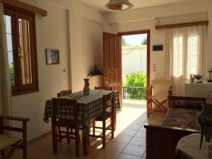 uma sala de jantar com uma mesa e cadeiras e uma janela em Livanina apartments em Kámpos